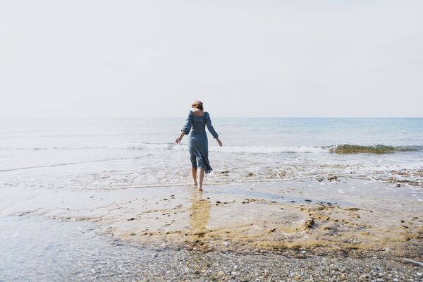 une jeune femme sur une plage face à la mer